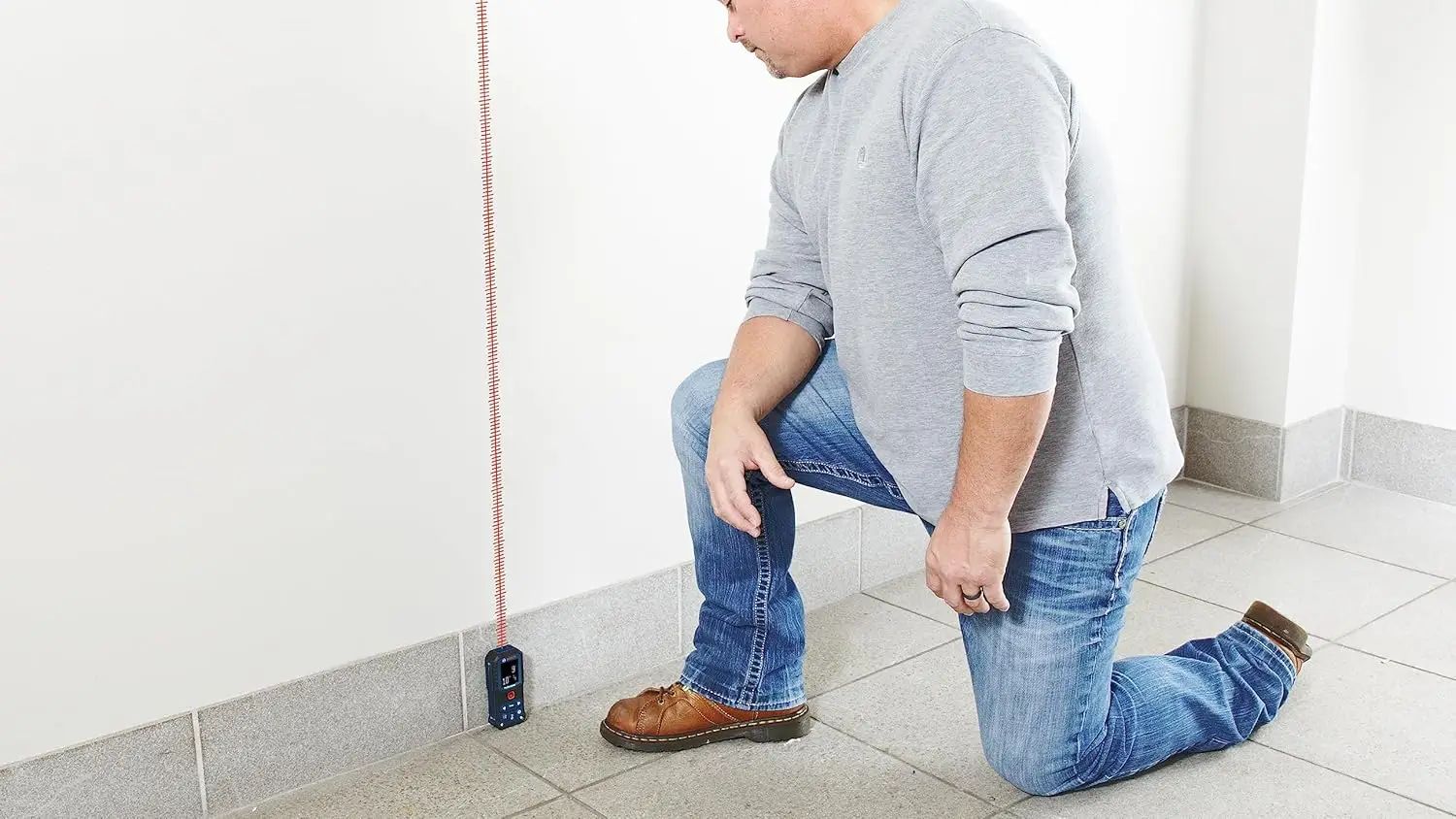 Bosch GLM165-22 laser measure box and accessories displayed on a workshop table